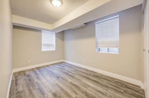A room with a window and a wooden floor.