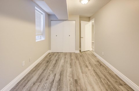 A room with a wooden floor and two white doors.