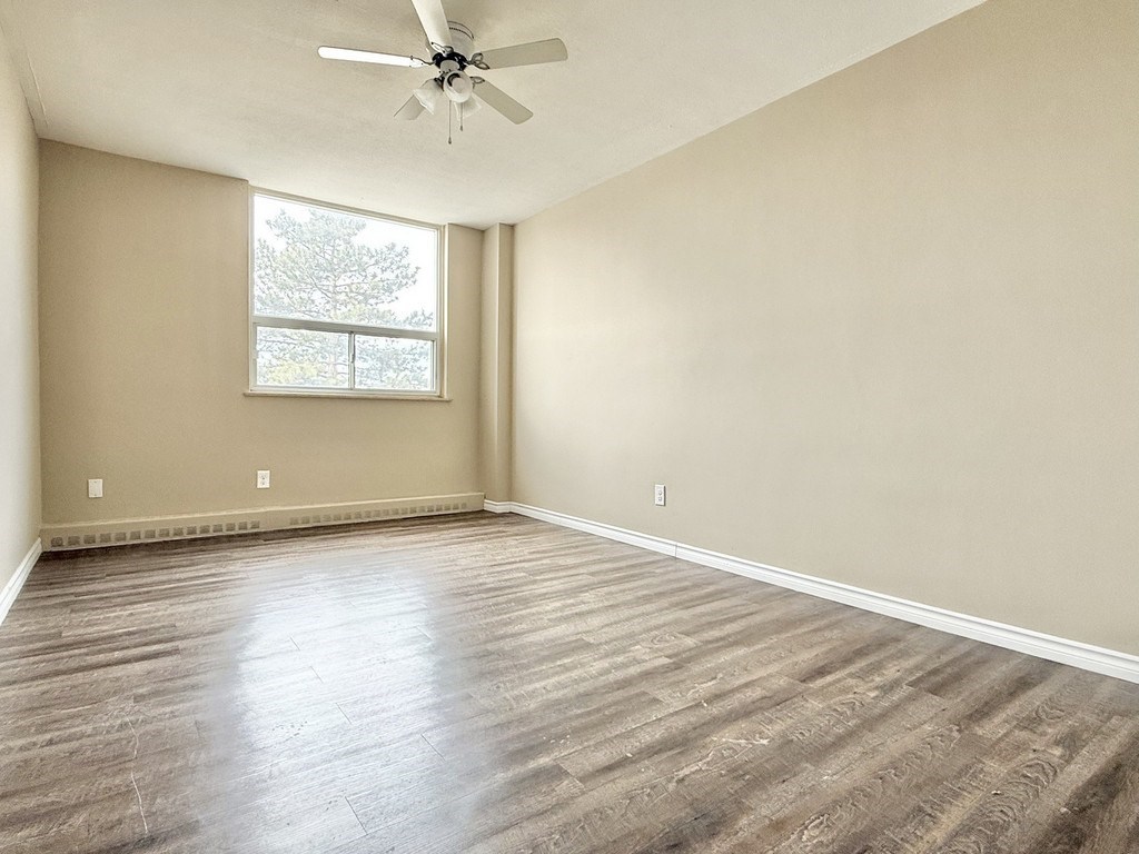 A room with a ceiling fan and a window.