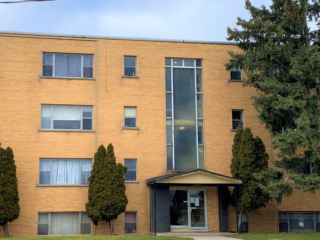 A red brick building with a black door and windows.