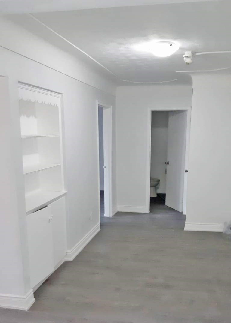 A white hallway with a door on the right.