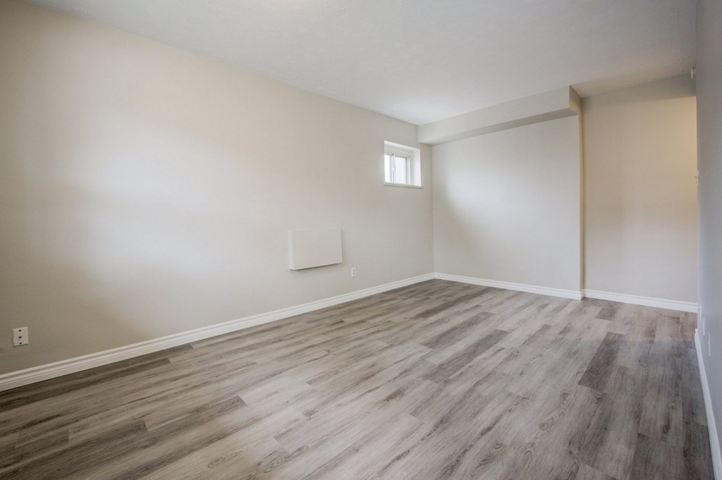 A room with wooden flooring and a window.