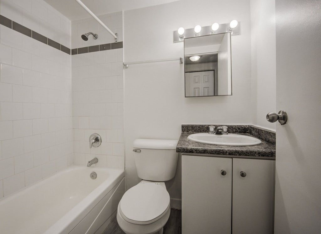 A white bathroom with a sink, toilet, and bathtub.