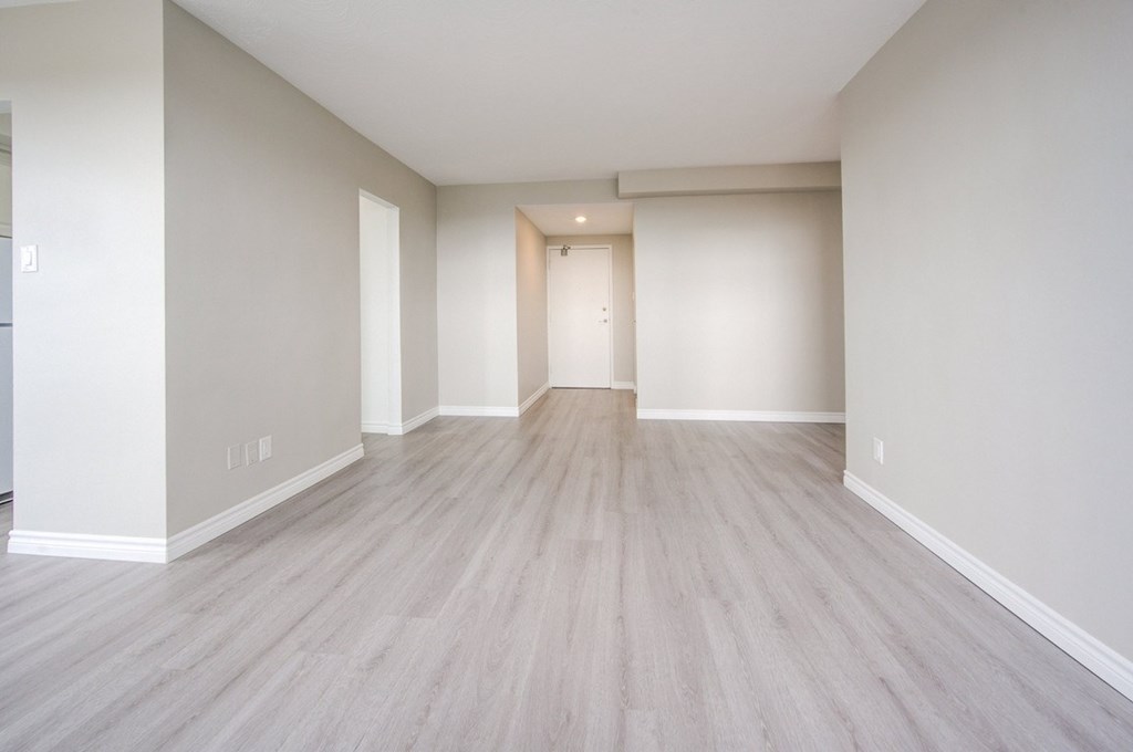 A room with light wood flooring and white walls.