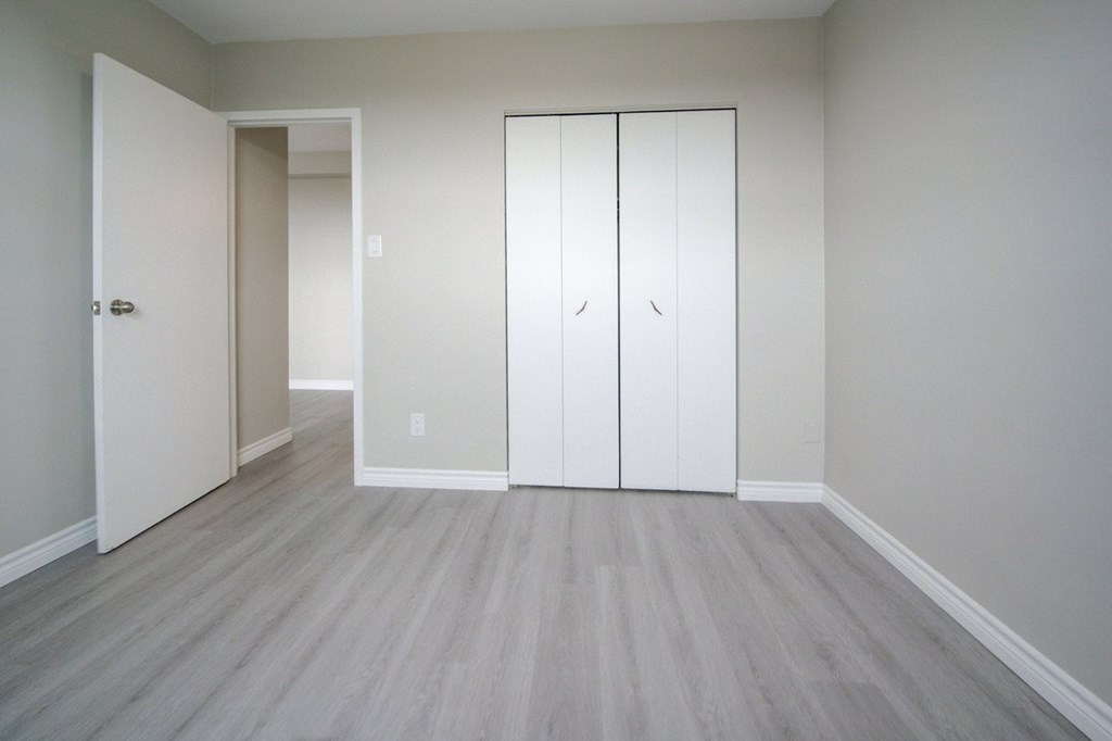 A room with a white door and a white wardrobe.