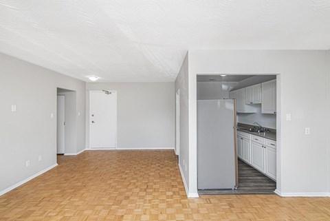 A kitchen area with a refrigerator, sink, and cabinets.