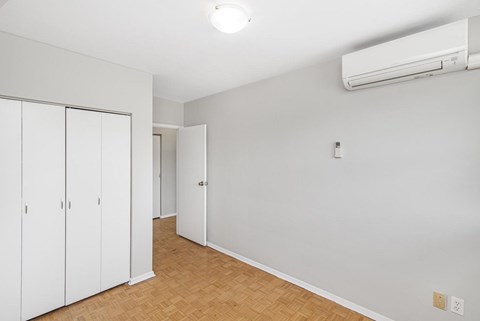 A room with a white wall and a white door with a white cabinet.