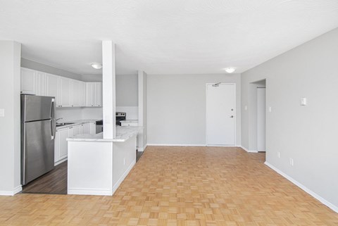 A kitchen with white cabinets and a refrigerator.