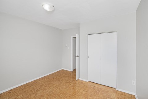 A room with a wooden floor and a white closet.