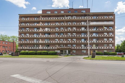 A large apartment building with a parking lot in front.