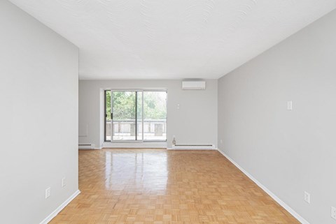A room with wooden flooring and a window.