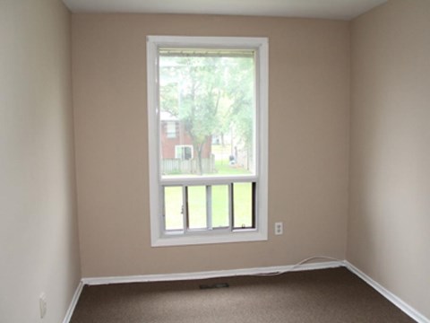A room with a window and a carpet floor.