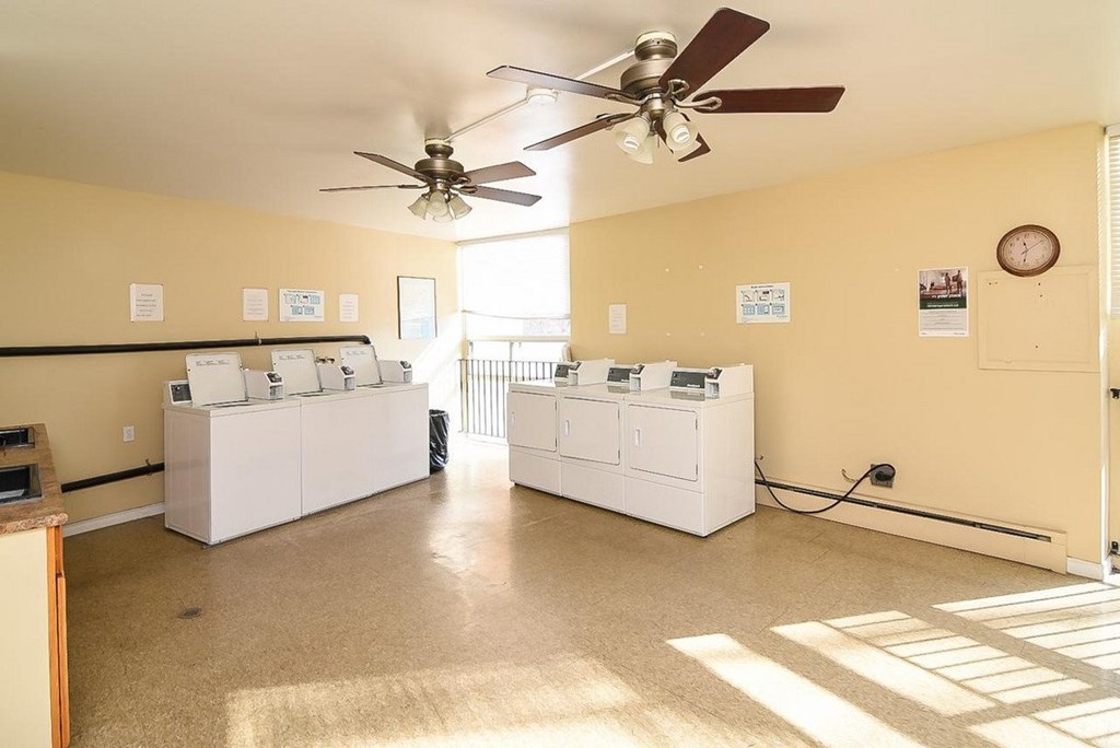 A room with a ceiling fan and a clock on the wall.