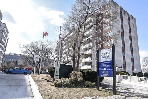 A sign for the Robinson Towers stands in front of a large building.