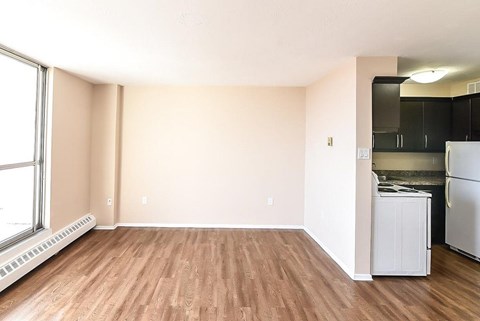 A kitchen area with a refrigerator, stove, and cabinets.