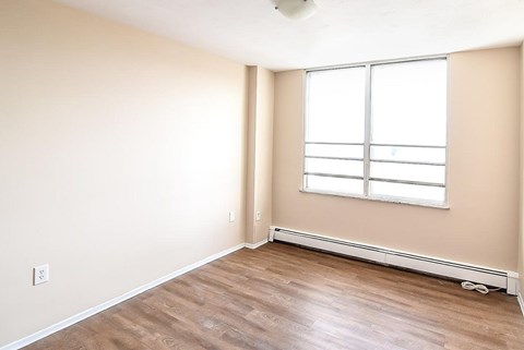A room with a window and a radiator on the wall.