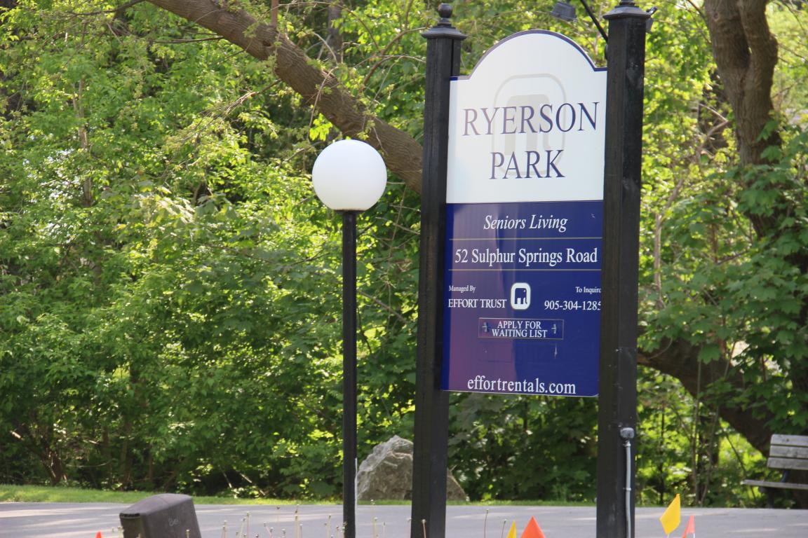 A sign for Ryerson Park is displayed in front of a tree.