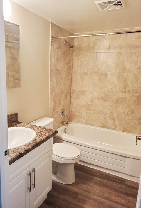 A bathroom with a toilet, sink, and bathtub.