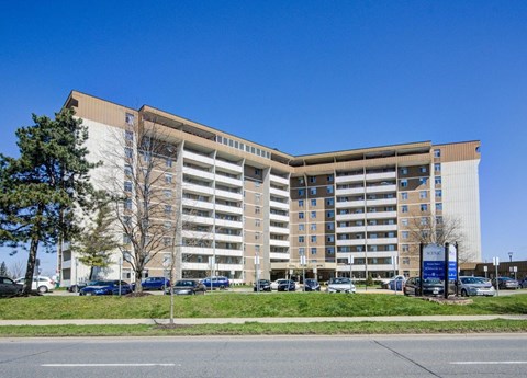 A large, modern building with a parking lot in front.