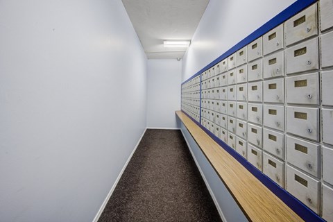 A long hallway with a row of mailboxes on the wall.