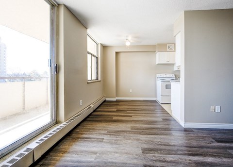 A room with a window and a wooden floor.