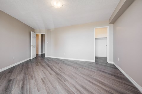 A room with a wooden floor and two doors.