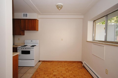 A kitchen with a white stove and wooden cabinets.