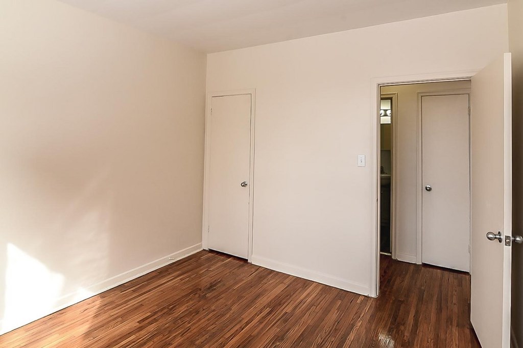 A room with two doors and a wooden floor.