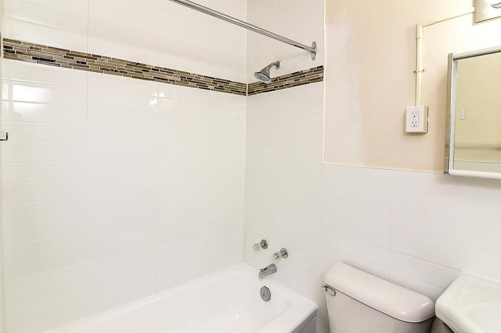 A white bathroom with a tub, toilet, and sink.
