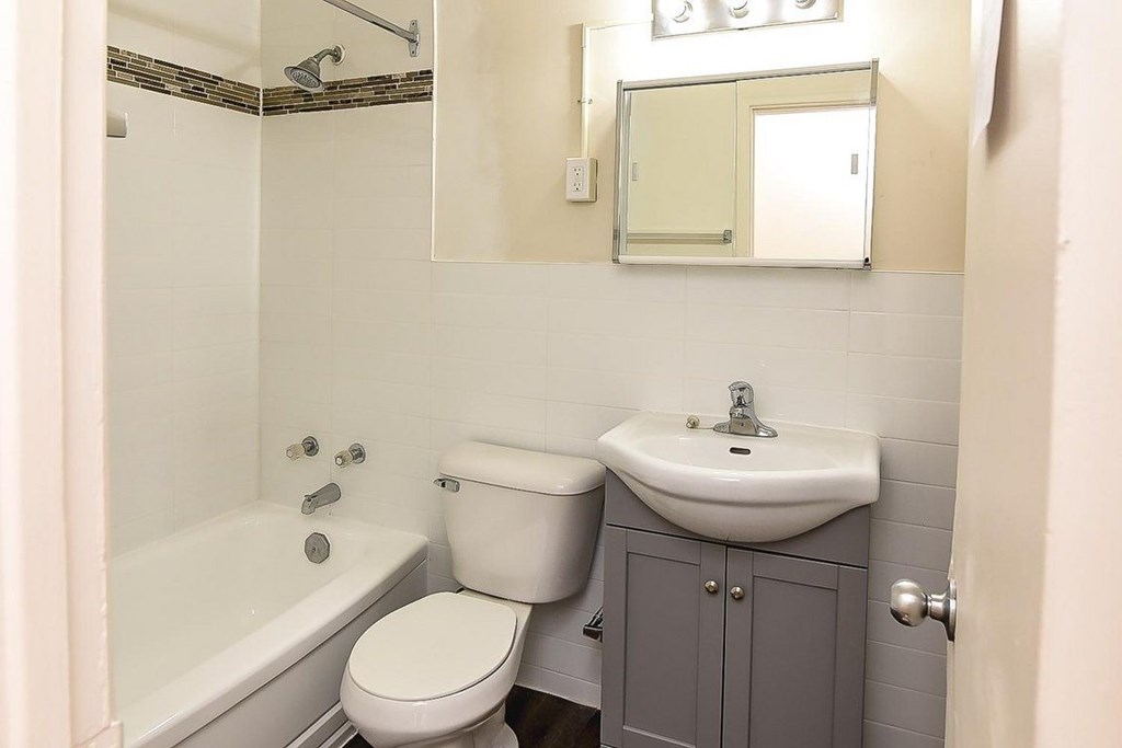 A white toilet sits next to a sink in a small bathroom.