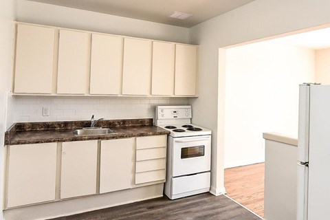 A kitchen with white appliances and cabinets.