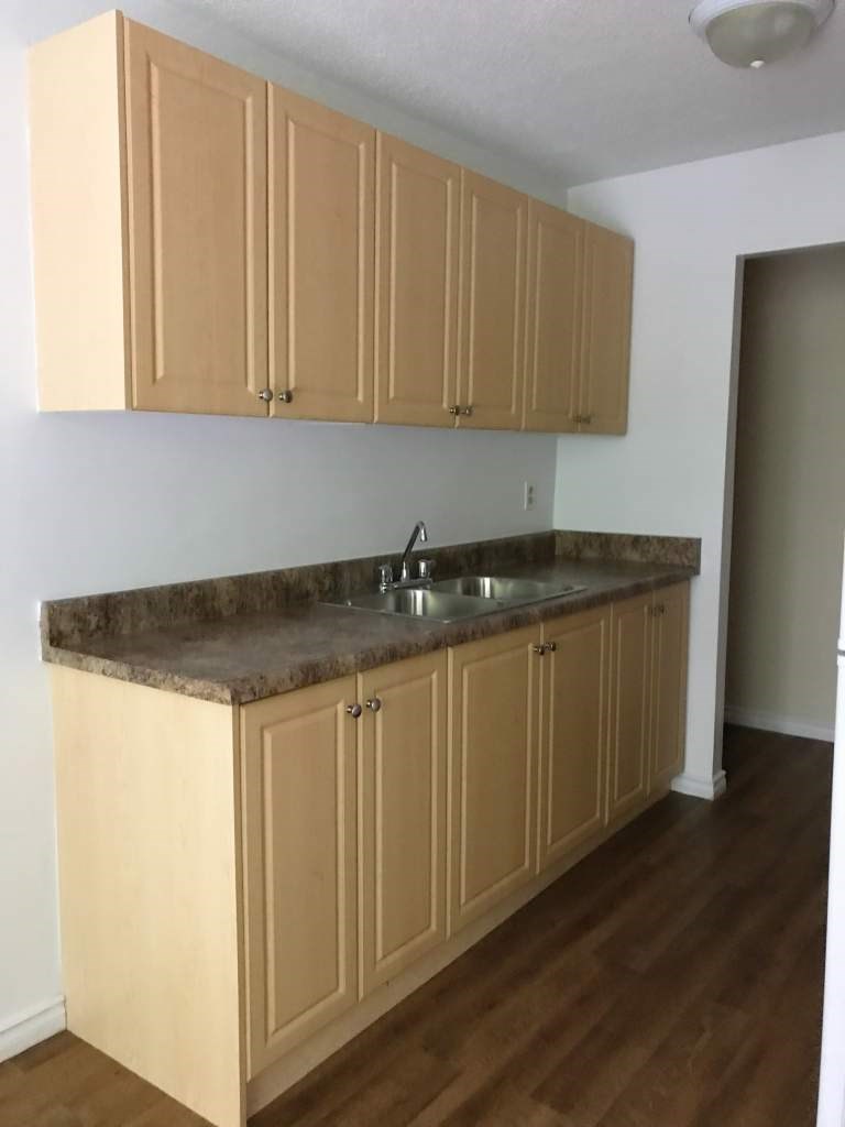 A kitchen with wooden cabinets and a granite countertop.