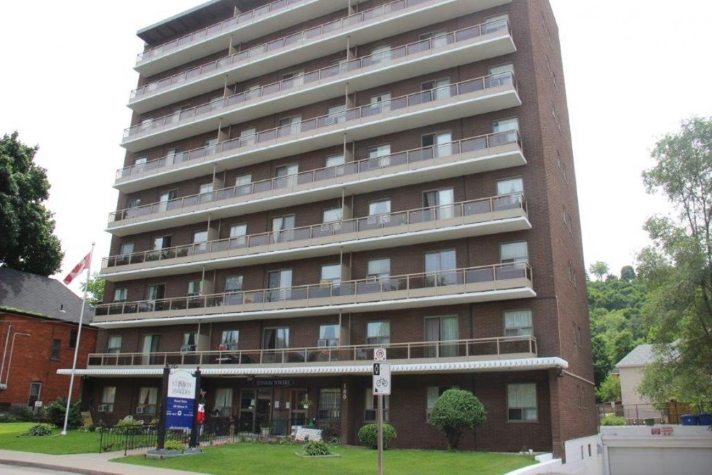 A tall apartment building with a sign in front of it.