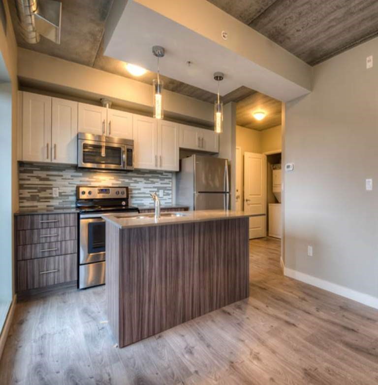 A kitchen with a wooden island and stainless steel appliances.