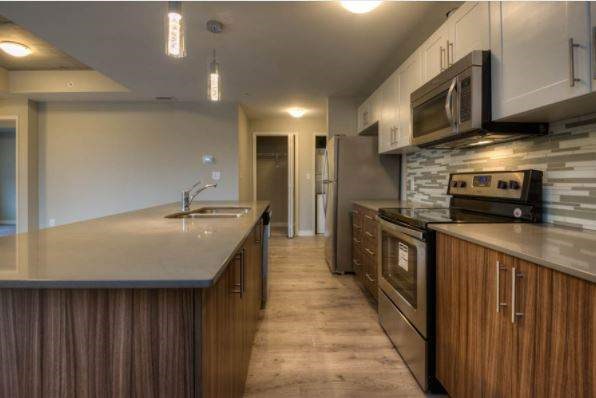A modern kitchen with wooden cabinets and stainless steel appliances.