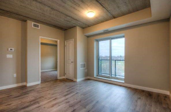A room with a large window and wooden floors.