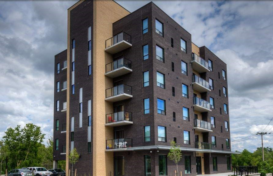 A modern apartment building with balconies and multiple windows.