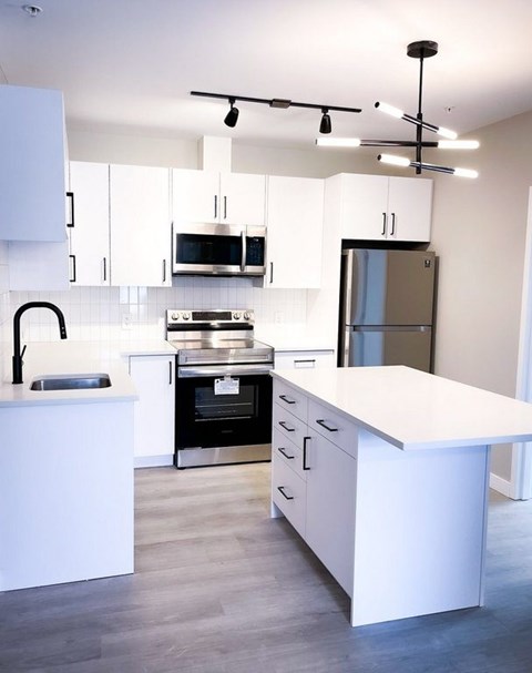 A modern kitchen with white cabinets and a large island.
