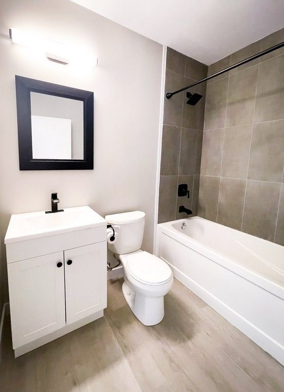 A white toilet sits next to a white sink in a bathroom.