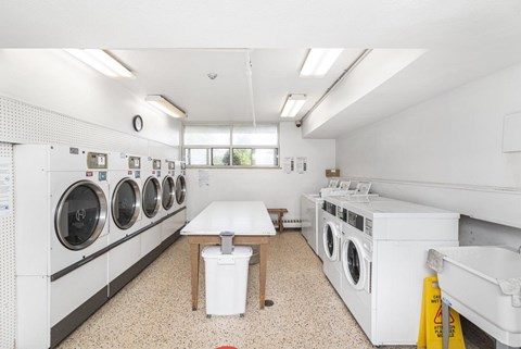 A laundromat with a row of washers and dryers.