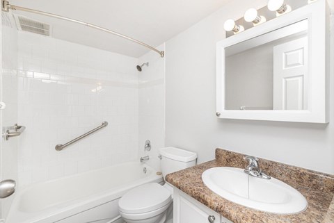 A white bathroom with a sink, toilet, and bathtub.