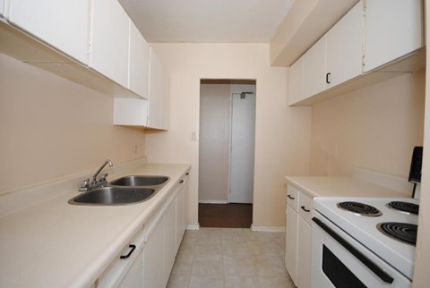 A kitchen with white cabinets and a stove top oven.