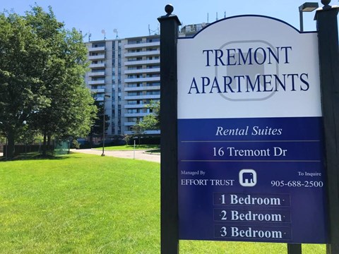 A sign for Tremont Apartments with a blue background and white text.