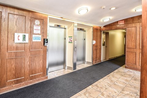 A hallway with a red exit sign on the wall.
