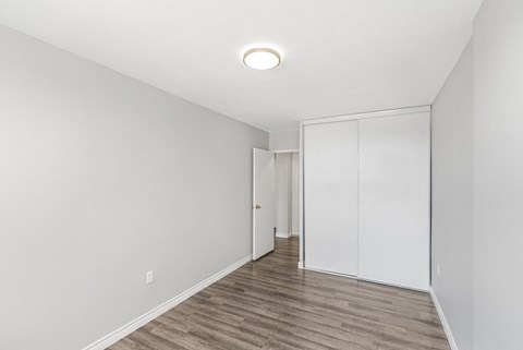 A room with a white wall and a wooden floor.