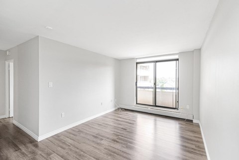 A room with a window and wooden flooring.