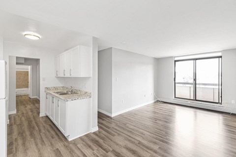 A kitchen with white cabinets and a marble countertop.
