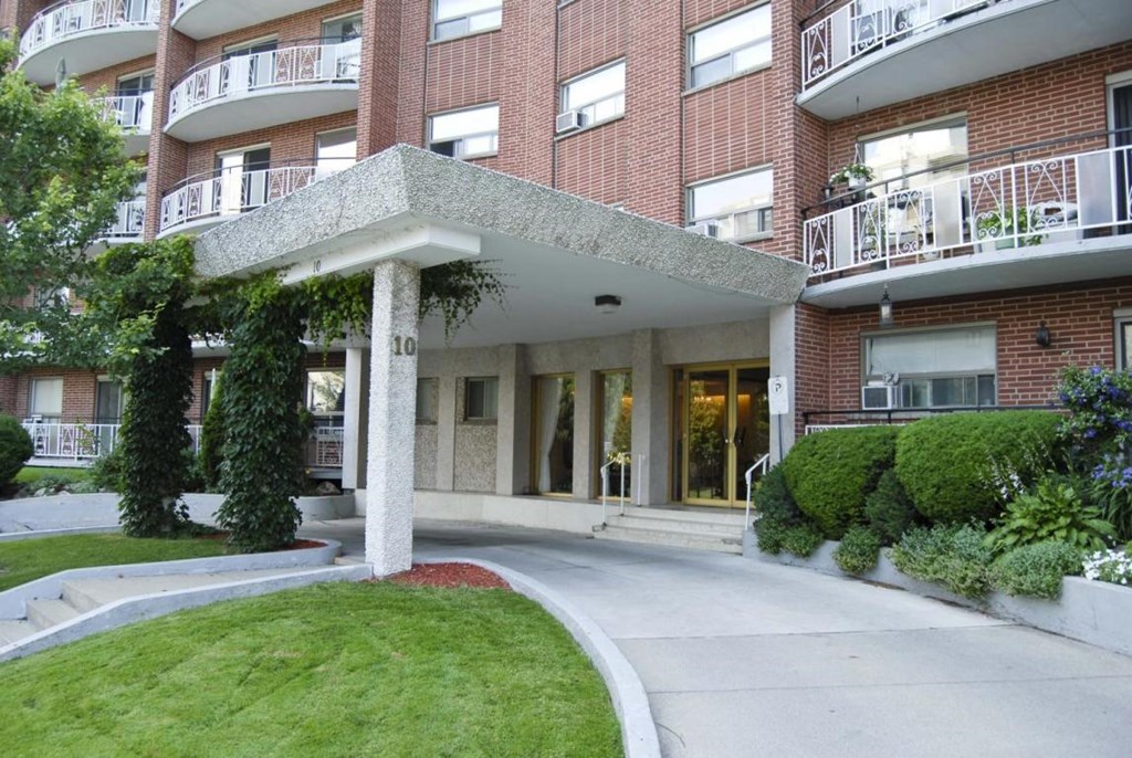 A red brick building with a white pillar in front.