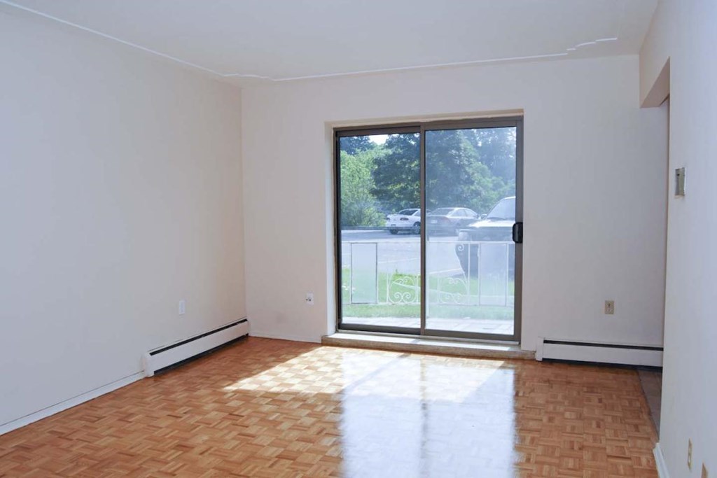 A room with a sliding glass door leading to a backyard.