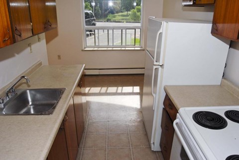 A kitchen with a white refrigerator and a stove top oven.